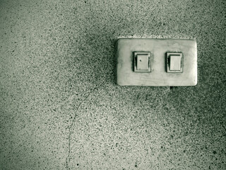 Dusted light switch on a dirty wall. Toned image.