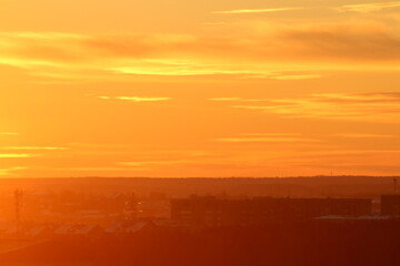 Sun below the horizon and clouds in the fiery dramatic orange sky at sunset or dawn backlit by the sun. Place for text and design