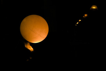 Bulb in shape of a sitting baby with a row of lamps in the distance symbolizing loneliness. 