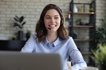 Female customer support operator with headset and smiling.