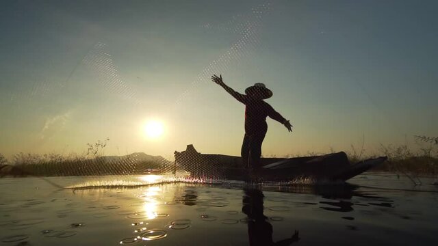 Slow motion of asian fishermen use traditional fishing nets in the lake