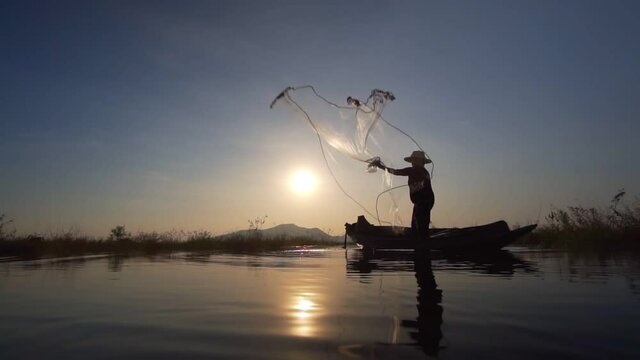 Slow motion of asian fishermen use traditional fishing nets in the lake