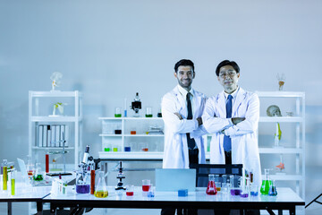Portrait of caucasian and asian in modern scientific laboratory working together.