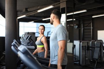 Fototapeta na wymiar Healthy sport couple running on a treadmill in a sport gym.