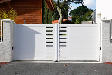 door white new metal driveway entrance gates portal in modern suburb house