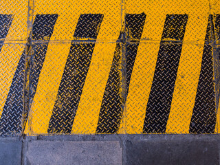 Yellow hazard stripe texture background. Symbol black yellow on metal sheet.