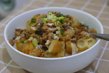 Bubur ayam / chicken porridge is Indonesian rice porridge with shredded chicken and chunks of cakwe.