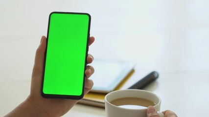 Handheld Camera: business woman using smartphone viewing green screen on mobile phone browsing chroma key online watching enjoying drinking coffee reading social media close up hands - Powered by Adobe