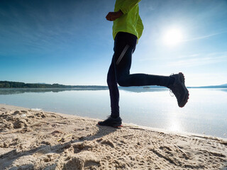 Male runner exercise at morning bay. Fit and healthy man in sports clothing jogging outdoors