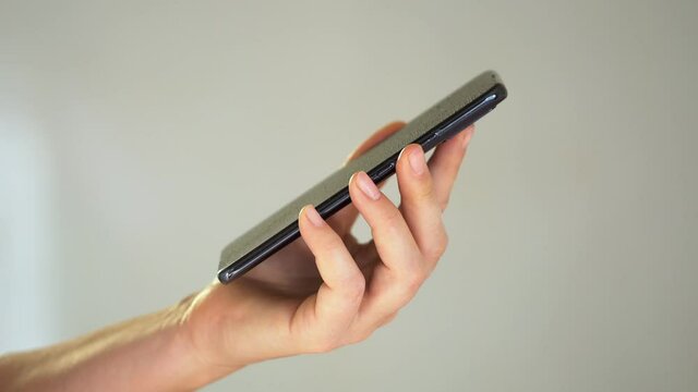 Close-up of woman hand using wet wipe and sanitizer to clean cell phone screen. People cleaning and disinfecting mobile telephone monitor to kill virus and germs. Female hands holding smartphone