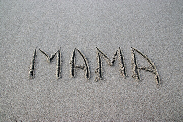 Inscription on the sand mother. The word mother is written in Russian.
