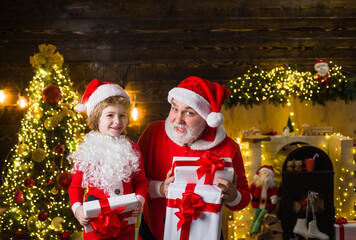 Fototapeta na wymiar Santa with helper. Christmas present. Little child with Santa Claus. Christmas gift. Christmas. Ad.