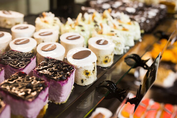 variety of sweet delicious cakes on the shop window of a cafe
