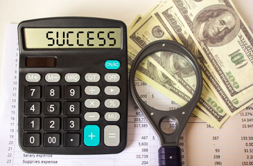 Success text on calculator . Business concept on white background calculator, dollars and magnifier .