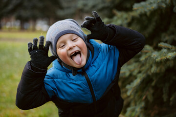 7 years old caucasian boy making funny face in park