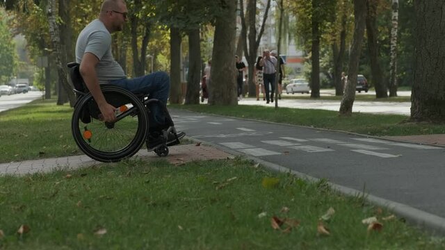 Handicapped man in wheelchair crossing street road