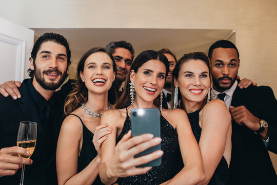  Multi-ethnic group of people taking a selfie at a party