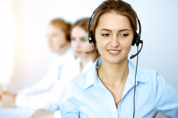 Call center. Focus on beautiful business woman in headset