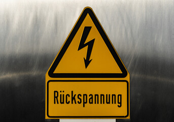 Rückspannung Warnschild