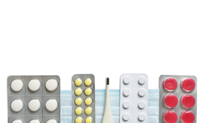 Pills, vitamins and a thermometer on a white background for the treatment of flu and colds