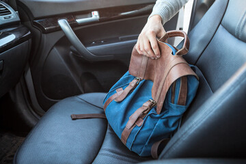 The action of stealing bag from passenger seat of car, male arm reach out for a handbag through the...