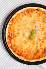 Homemade Neopolitan Pizza with Cheese and Basil, view from above. Flat lay, top view, overhead.