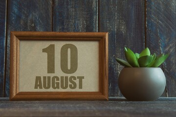august 10th. Day 10 of month, date in frame next to succulent on wooden background summer month, day of the year concept
