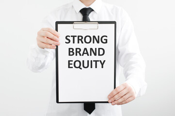 STRONG BRAND EQUITY is written on white paper held by a man.