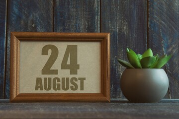 august 24th. Day 24 of month, date in frame next to succulent on wooden background summer month, day of the year concept