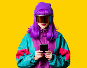 Style woman in VR glasses and 80s tracksuit with mobil ephone on yellow background
