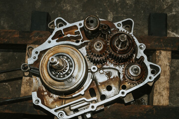 The mechanic is assembling the crankshaft and motorcycle gear.