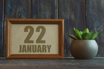january 22nd. Day 22 of month, date in frame next to succulent on wooden background winter month, day of the year concept