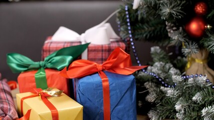 Christmas Tree with red and gold balls. Lots of gift boxes of presents under the tree. New year presents, festive and holiday shopping. Colorful holidays decoration. Christmas greeting card. 