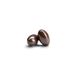 Close-up of a couple pills or capsules color brown on isolated white background.