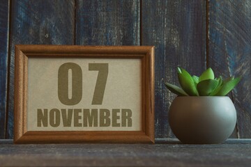 november 7th. Day 7 of month, date in frame next to succulent on wooden background autumn month, day of the year concept