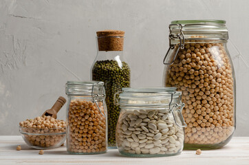 Jar with beans and legumes on gray background with space