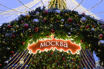 the word Moscow from glowing lights garlands on a decorated Christmas tree