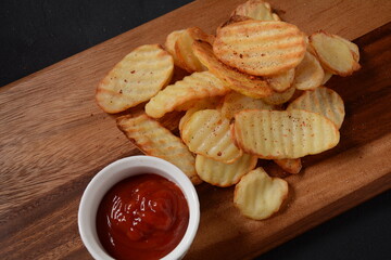 Naklejka premium Homemade rippled potato chips and sauce, ketchup