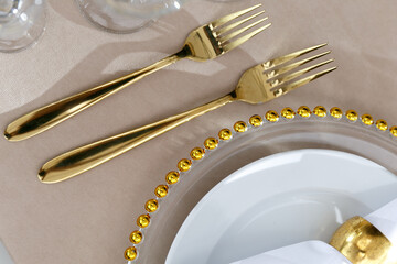 Wedding decorations. Plates are white with a gold frame. Gold cutlery.