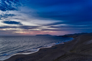 sunset at the coast line of Peru during blue hour at Paracas national park. dramatic eveneing sky
