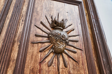 spanish colonial building with large antique wooden door with ornaments in the shape of a heart, Peru, South America