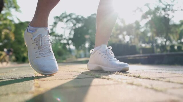 Close up shot man doing ankle rotation warm up exercise in the park, human joint ligament bone problem, ankle sprain sport injury prevention, healthy active lifestyle, outdoor running on sunny day