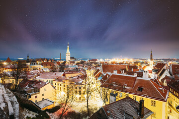 Tallinn, Estonia. Night Starry Sky Above Traditional Old Architecture Cityscape Skyline In Old Town. Winter Evening Night. Famous Landmark. Popular Destination Scenic. Altered Sky With Glowing Stars