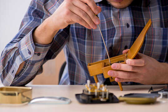 Young male watchmaker working in the workshop