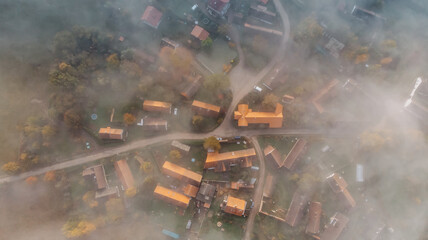 Aerial view of a small village in fog.Top view of traditional housing estate in Czech.Looking straight down with a satellite image style.Houses from above, real estate concept.Foggy landscape