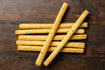 Homemade Italian Grissini Breadsticks on a wood background. Traditional italian snack with herbs.  Space for text.