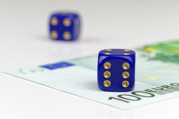 Two blue dices and 100 euro banknote on white background