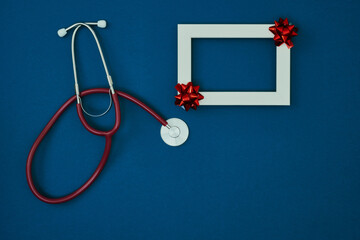 Stethoscope and frame on a blue background. Christmas and New Year's pandemic. Copy space, mock up.