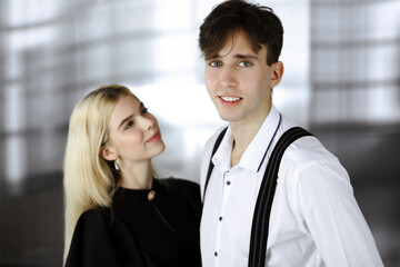 Obraz premium Young couple of businessman and woman are standing in a modern office. Portrait of successful business people