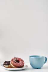 Mug and donuts cakes on a white background. Confectionery, coffee shop. Copy space, mock up.